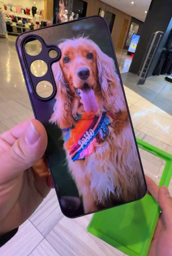 Custom phone case printed with a photo of a golden cocker spaniel dog being held inside a shopping centre