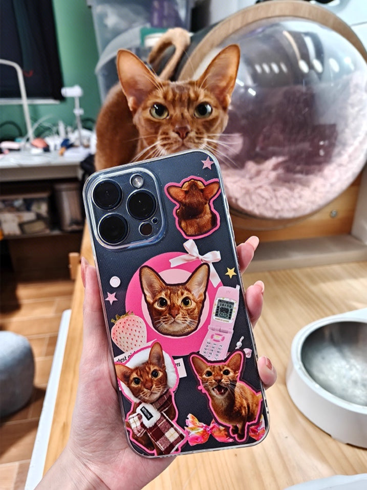 Person holding a custom phone case printed with multiple cute cat photos while the real cat looks at the camera in the background
